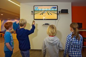 Kinder spielen mit Spielekonsolen (WII)